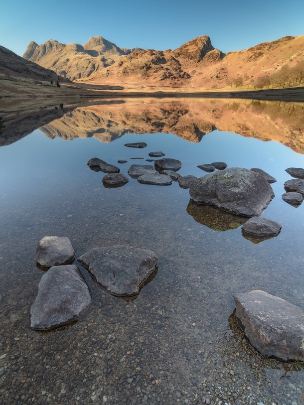 A clear spring afternoon with the Langdale Pikes reflected in Blea Tarn 