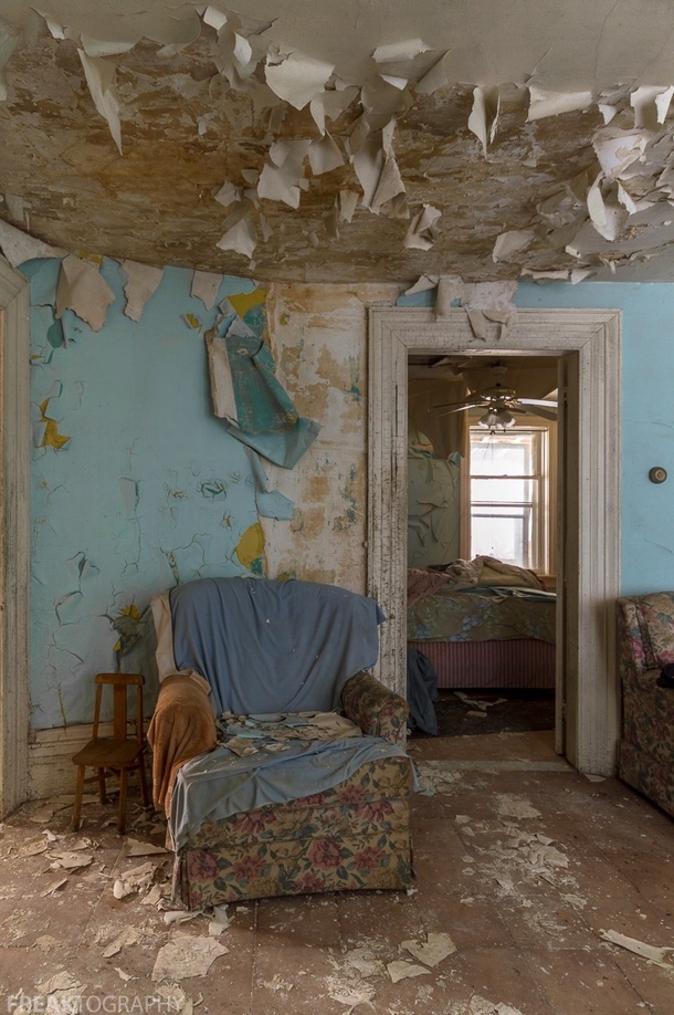 A cozy chair surrounded by peeling paint and decay in an abandoned house in Ontario Canada c   