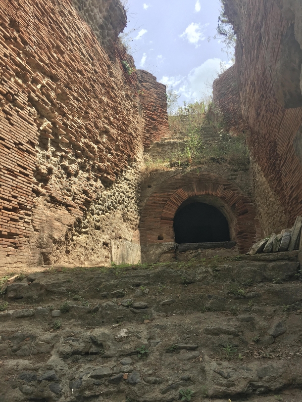 A partially collapsed staircase leading to spectator seats at the Flavian Amphitheater of Pozzuoli the third-largest Roman arena in Italy The arch below supports a passageway now exposed by damage The complex based on the Colosseum was constructed by Vesp