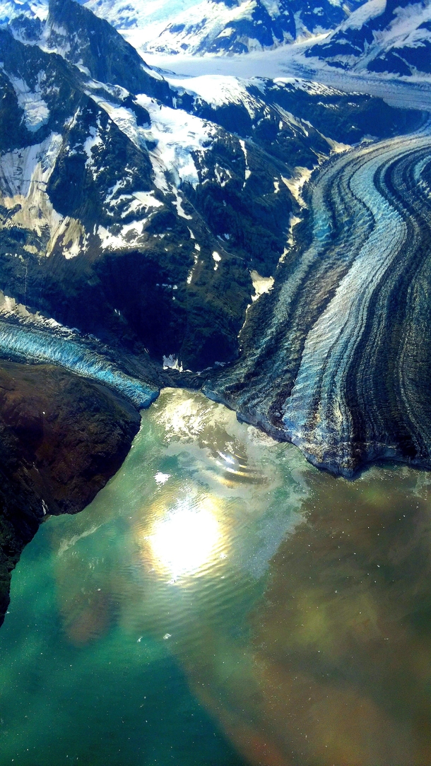 A photo I took during an aerial tour of Glacier Bay National Park in Alaska The Lamplugh glacier is stunning in the sun 
