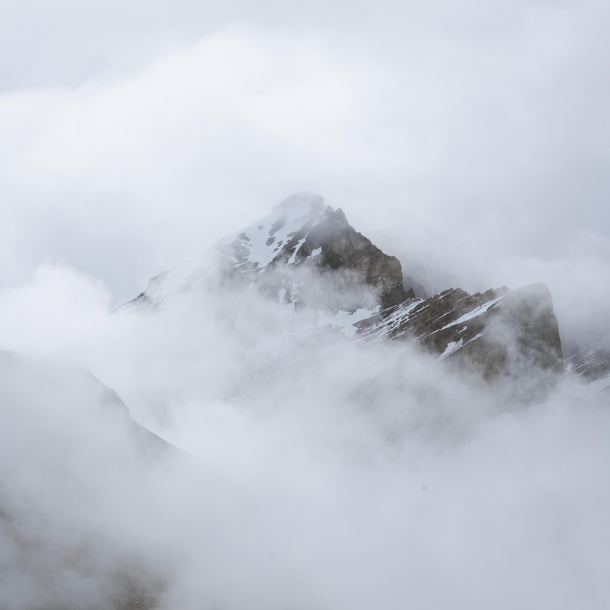 A sea of clouds engulfing a mountain peak in Banff National Park 