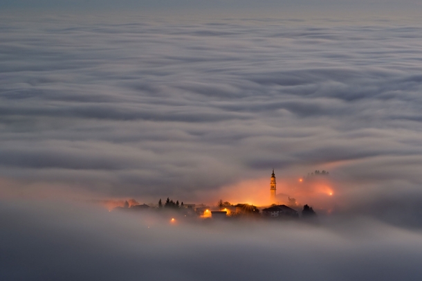A town shrouded in fog on the Asiago Plateau Italy 
