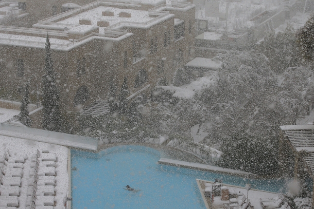 A woman swims in the pool at the David Citadel Hotel during a snow storm in Jerusalem 