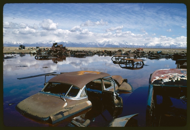 Abandoned automobiles and other debris clutter an acid water- and oil-filled five-acre pond Ogden Utah 