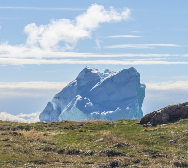 Abandoned island in Greenland with a view of a large iceberg near Qasigiannguit Greenland 