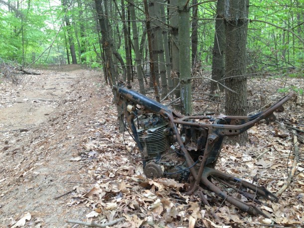 Abandoned motorcycle on the side of a motocross trail in the woods OC 