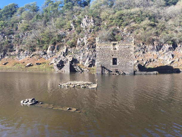 Abandoned water mill sits crumbling in a French lake
