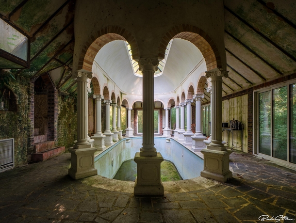 An abandoned swimming pool in the architecture style of Ancient Greek France 