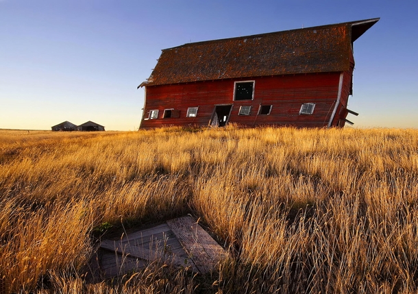 An old barn reshaped and missing its doors as a result of years of westerly winds on the Canadian Prairies Shot in the province of Saskatchewan by SYMPL IMAGES 
