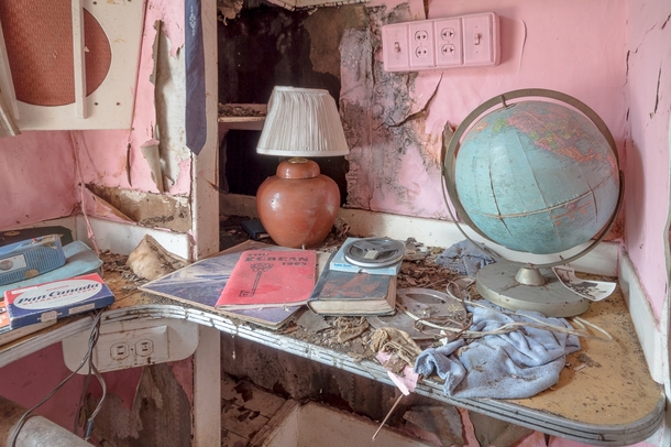 An old globe and miscellaneous items on a desk in an abandoned house OC   