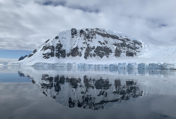 Antarctic Peninsula Cloudy Day Reflection  Coastal MountainGlacier Perfectly Mirrored Against Icy Ocean 