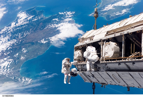 Astronauts Robert Curbeam and Christer Fuglesang performing a spacewalk over New Zealand 