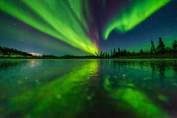 Aurora reflecting on a frozen lake near Yellowknife Northwest Territories Canada 