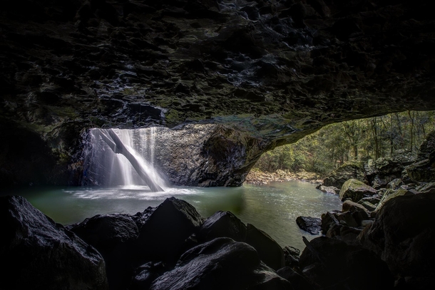 Australias Natural Bridge waterfall water plummeting through a massive cavern of rock 