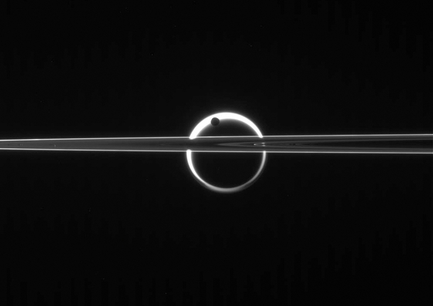 Beyond Enceladus and Saturns rings Titan Saturns largest moon is ringed by sunlight passing through its atmosphere Enceladus passes between Titan and Cassini in this image made on June   NASA  JPL  Space Science Institute 