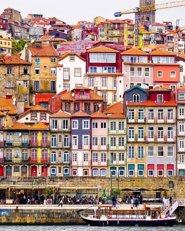 Colorful houses in the historic Ribeira neighborhood facing the Douro River flowing through Porto Portugal