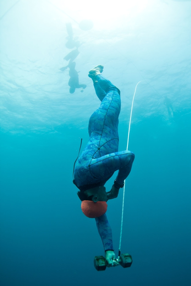 Dropping weighted and blindfolded  feet underwater on a single breath-hold during Waterman survival course For surfers and freedivers 