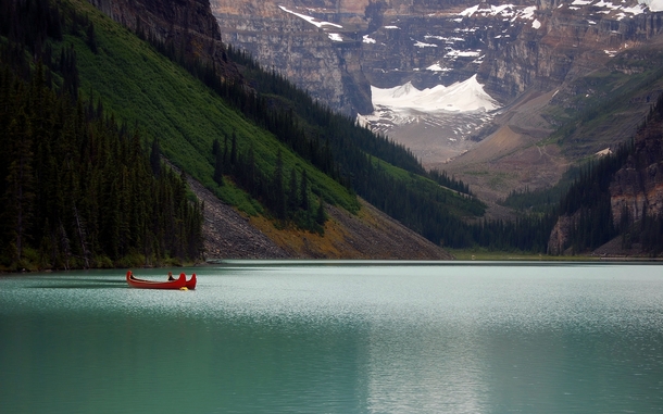empty canoes resting on the calm water of Lake Louise in Alberta Canada  OP