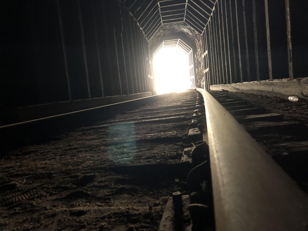 Exiting a abandoned dark train track tunnel in California