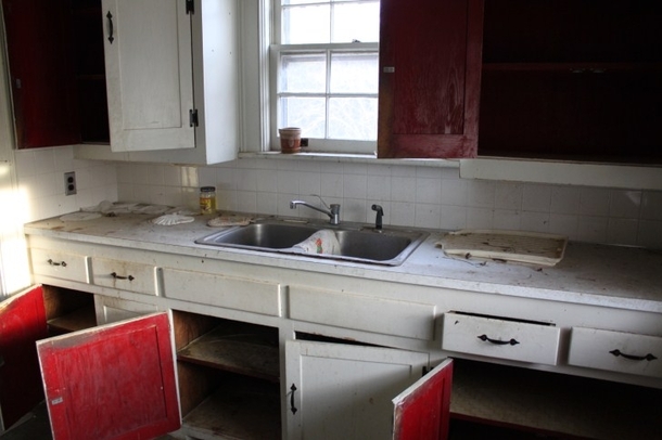 Fantastic red cabinet interiors of the kitchen in this quaint abandoned house 