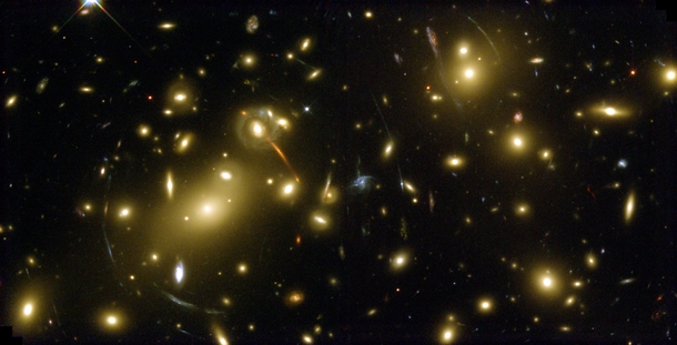Gravity can bend light allowing huge clusters of galaxies to act as telescopes Almost all of the bright objects in this image are galaxies in the cluster known as Abell  Its so massive and compact that its gravity bends and focuses the light from galaxies