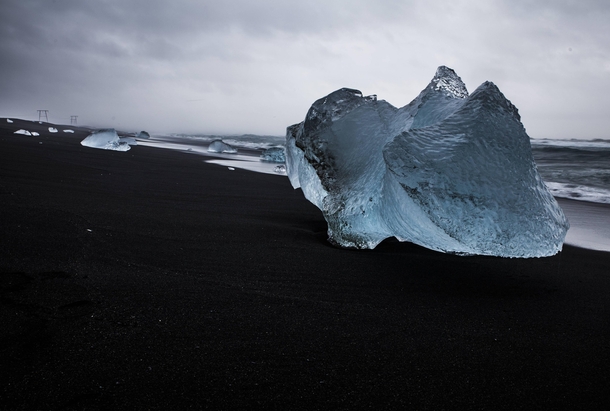 Ice chunks wash up on the shore of a black sand beach at Jokulsarlon Iceland 