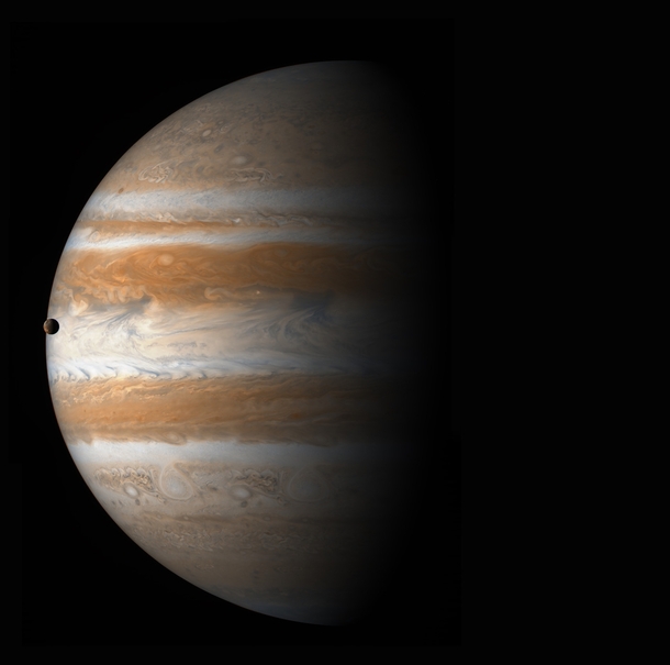 Jupiter with its moon Io visible just at the edge of the planet 