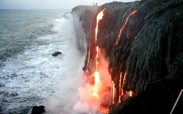 Lava falling in the ocean from a cliff in Hawaii 
