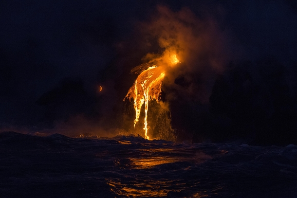 Lava lights up the ocean waters in the darkness at Hawaiis G volcano flow 