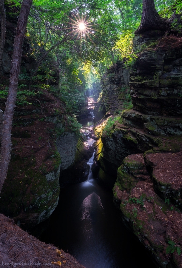 Light bursts through the trees onto the waterfalls of Skillet Creek in Pewits Nest Wisconsin 