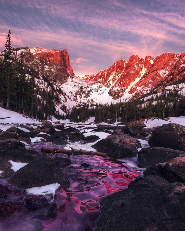 Magical alpine glow within Rocky Mountain NP The frozen river reflects the beautiful light from the mountains above 