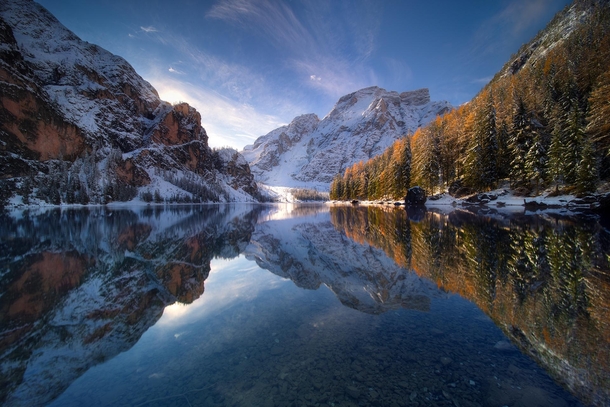 Mirror reflection on Lago di Braies during a cold sunrise in November - Dolomites Italy 
