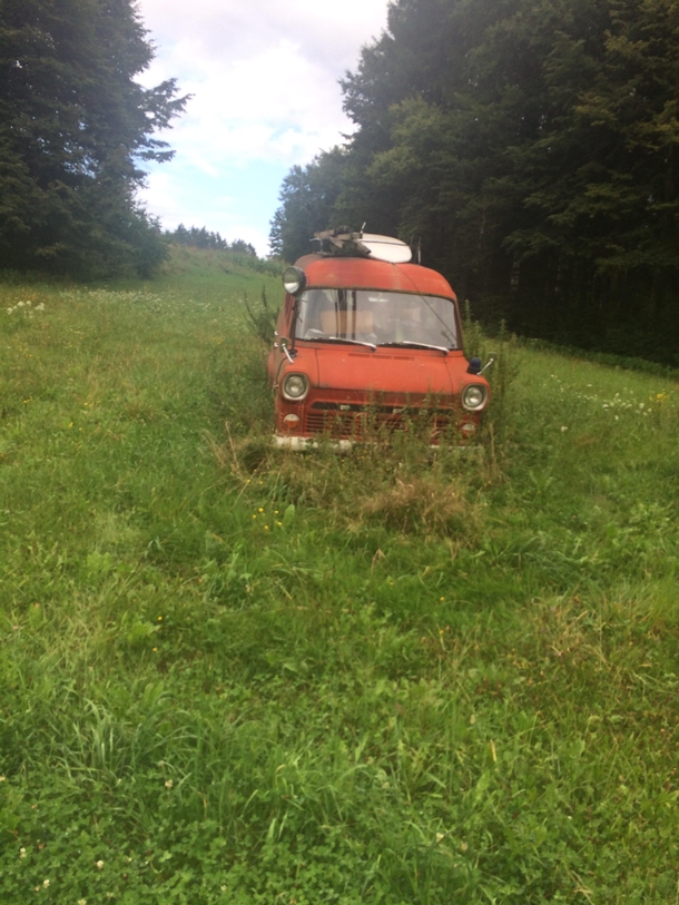 Old firetruck turned camping bus abandoned with surf board on top in Styria Austria 