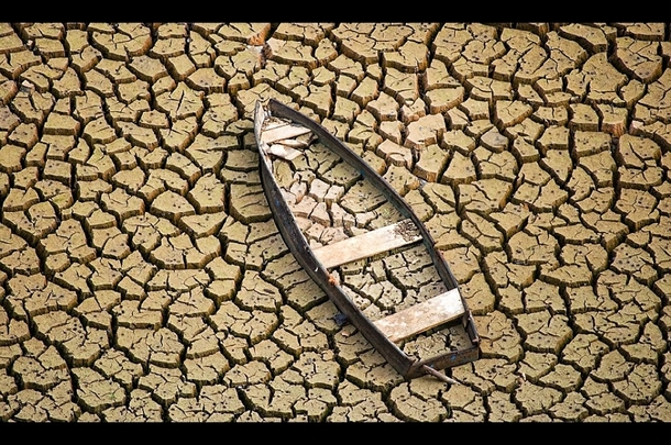 Old row boat in a dry and cracked river bed 