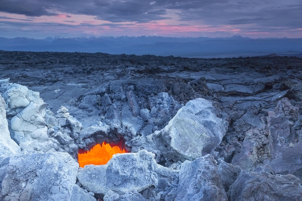 On the lava field - the orange glow of hot molten rock beneath Kamchatkas volcanic hellscape  photo by  