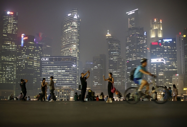 People take photos with the skyline of the central business district shrouded by haze in Singapore on September   Edgar Su 