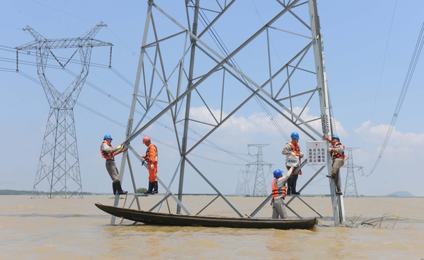 Reinforcing electric pylons at a flooded area in Xuancheng China 