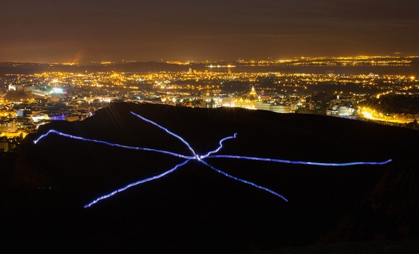 Runners taking part in NVAs Speed of Light create a visual display with their LED suits during a performance on Arthurs Seat in Edinburgh 