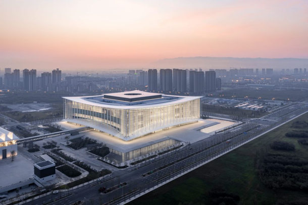 Silk Road International Conference Center by German firm Gerkan Marg and Partners The sweeping symmetrical shape of the roof the measured horizontal facade proportions and the column pattern are understood as references to traditional Chinese architecture