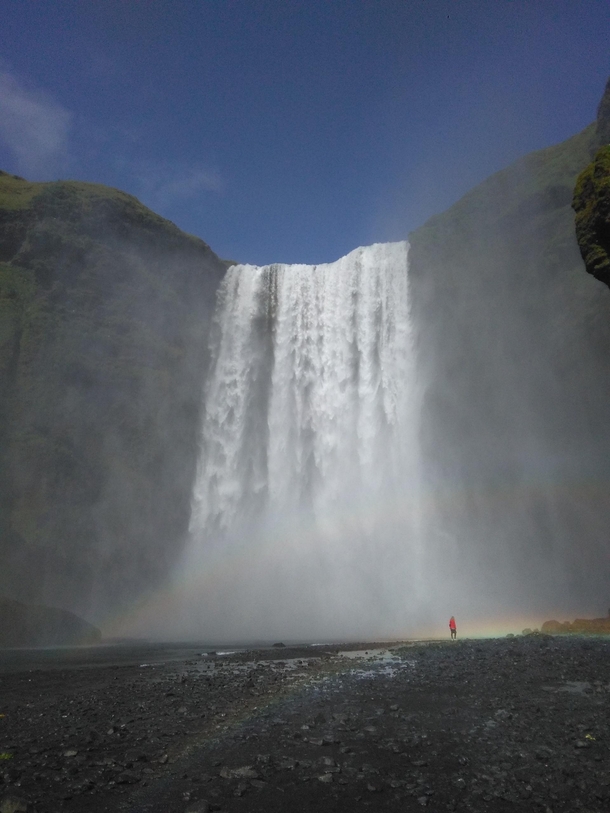 Skgafoff cascade in Iceland with rainbow and woman included 