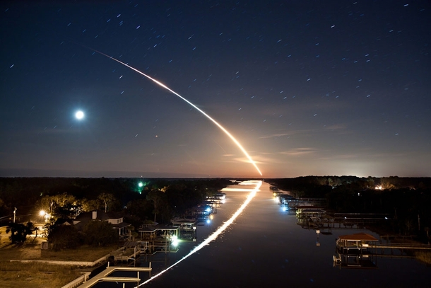 Space shuttle Endeavour STS- launches into orbit toward the east as the stars and waning crescent moon trail toward the west leaving a beautiful reflection on the Intracoastal Waterway in Ponte Vedra Florida 