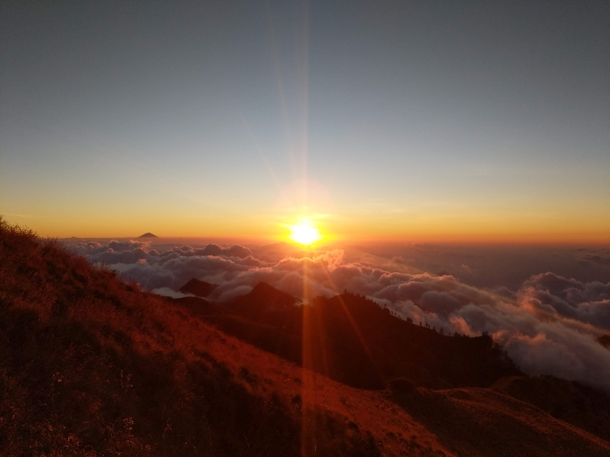 Sun setting in a sea of clouds seen from Mount Rinjani Indonesia 