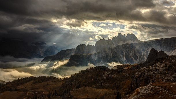 Sunlight Peeking through the Clouds near Croda da Lago Italian Dolomites  by ubo Balaovi
