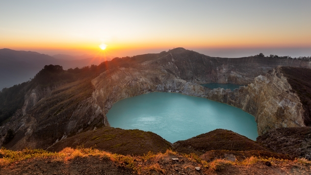 Sunrise atop a volcano Turquoise blue lakes fill the craters of Kelimutu on Flores island Indonesia 