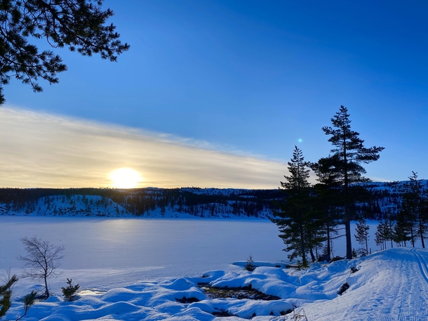 Sunset at  pm over a frozen lake Fagerfjell Norway  