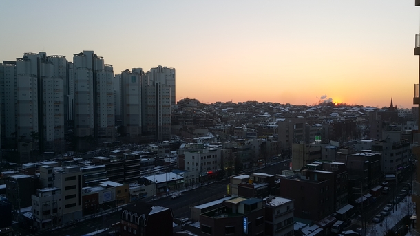 Sunset over the snow covered rooftops of Ahyeon neighborhood Mapo District Seoul South Korea 
