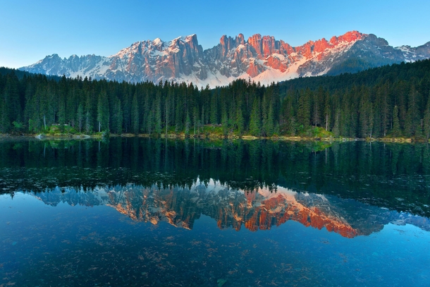 Sunshine in a mirror Carezza Lake in the Italian Dolomites Photo by Simone Panzeri
