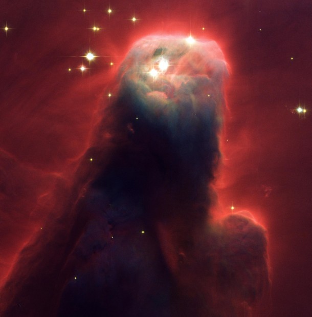 The Cone Nebula looks a nightmarish beast raising its head from a crimson sea 