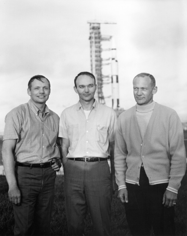 The crew of Apollo  poses in front of their Saturn V 