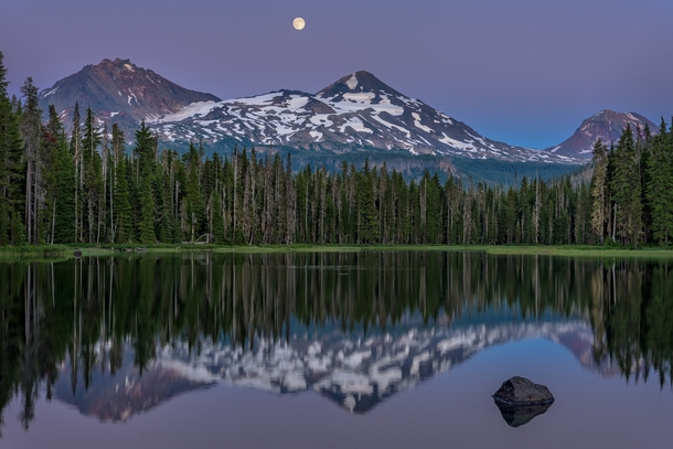 The moon rises over the Three Sisters Mountains at Scott Lake Oregon  by Kevin Brown